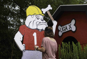 A volunteer paints Uga X