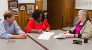 Sonya Fears signs papers at her home closing