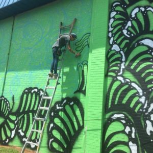 Jess Ulrich painting the ReStore mural