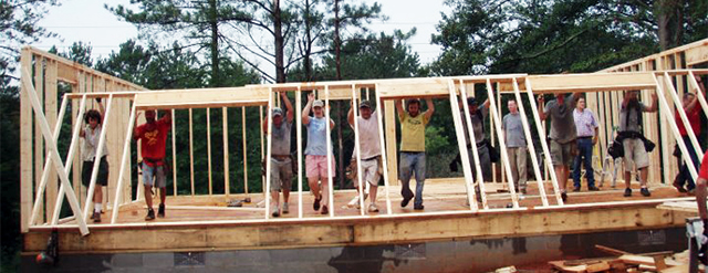 Madison County Habitat volunteers raise a wall on a new home