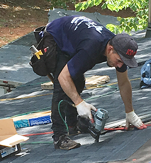 Roofer nailing shingles